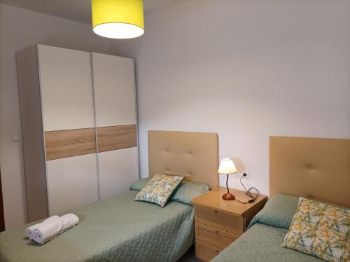 um quarto com 2 camas, um candeeiro e uma cómoda em Casa Enebro em Vélez de Benaudalla