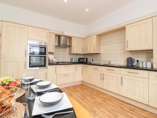 a kitchen with wooden cabinets and a black counter top at Church View in Grange Over Sands