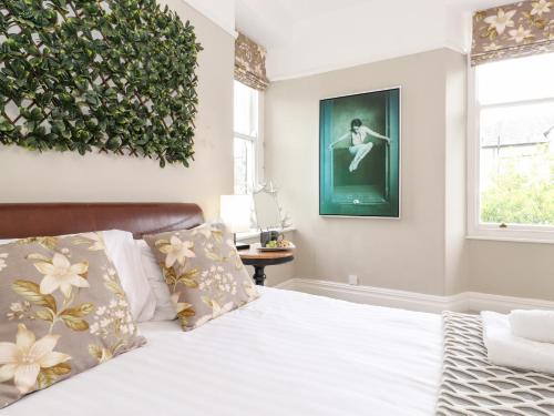 a bedroom with a bed with a plant on the wall at Church View in Grange Over Sands