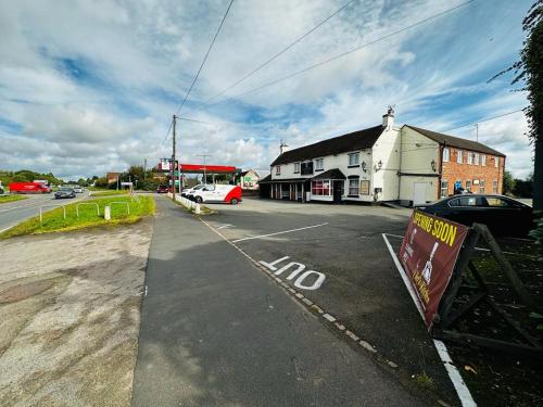 a parking lot with cars parked in front of a building at Leaking Well, Dunhampton in Stourport