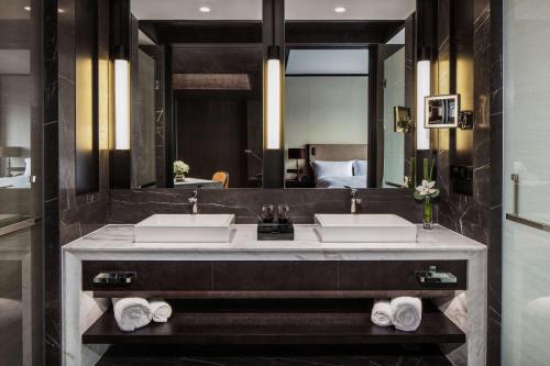 baño con 2 lavabos y espejo grande en Hilton Ningbo Dongqian Lake en Ningbo