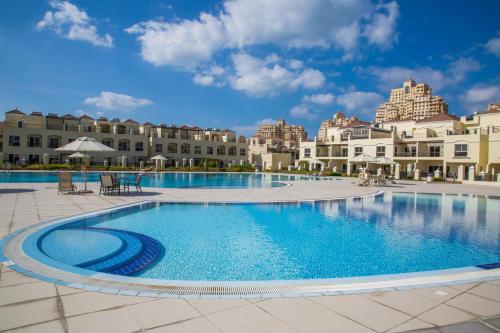 una gran piscina frente a un edificio en Hala Holiday Homes - Al Hamra Village, RAK en Ras al-Jaima