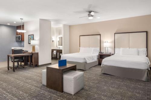 a hotel room with two beds and a desk at Homewood Suites By Hilton San Marcos in San Marcos