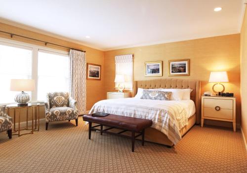 a bedroom with a large bed and a chair at The Grand Hotel in Kennebunk
