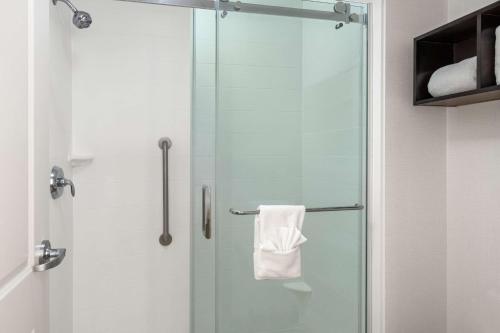 um chuveiro com uma porta de vidro e uma toalha em Homewood Suites By Hilton San Marcos em San Marcos