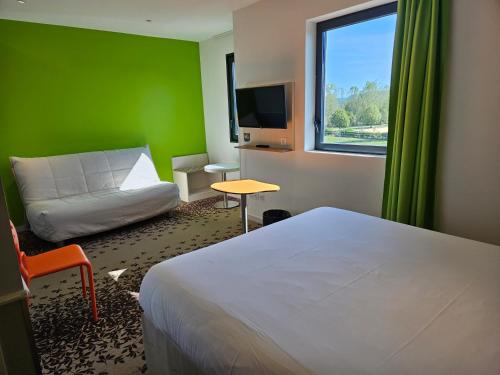 pokój hotelowy z łóżkiem i zieloną ścianą w obiekcie ibis styles Villeneuve Sur Lot w mieście Villeneuve-sur-Lot