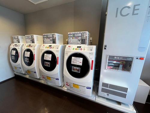 a row of washing machines on a shelf in a store at PORTA INN bentencho in Osaka