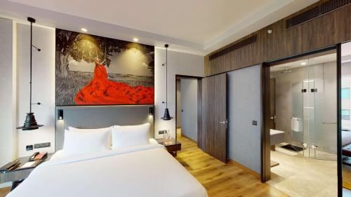 a bedroom with a large white bed and a bathroom at Radisson RED Chandigarh Mohali in Chandīgarh