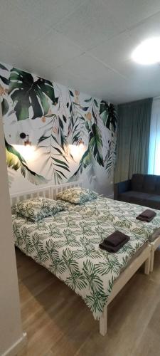 a bedroom with a bed with plants on the wall at Apartamenty Częstochowa in Częstochowa