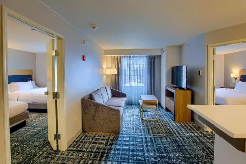Habitación de hotel con sofá, cama y TV en Homewood Suites by Hilton South Bend Notre Dame Area, en South Bend