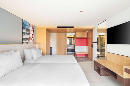 a bedroom with a large bed and a flat screen tv at Best Western Click Sathorn 11 Bangkok in Bangkok