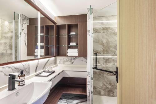 a bathroom with a tub and a sink and a mirror at Best Western Click Sathorn 11 Bangkok in Bangkok