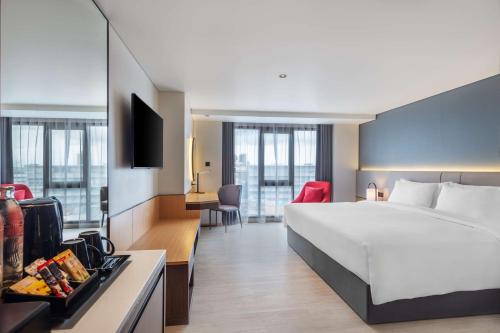 a hotel room with a large bed and a kitchen at Best Western Click Sathorn 11 Bangkok in Bangkok