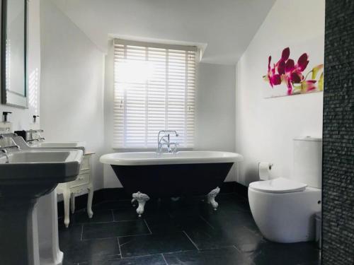 a bathroom with a tub and a toilet and a sink at Number Nine Torquay in Torquay