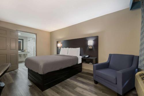 una camera con letto e sedia blu di Quality Inn & Suites Altamonte Springs Orlando-North a Orlando