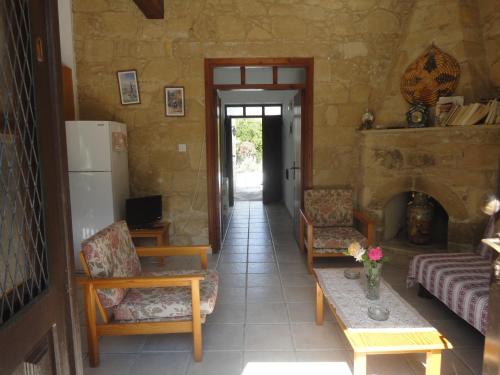 ein Wohnzimmer mit Stühlen und einem Kamin in der Unterkunft Spanos House in Goudhi