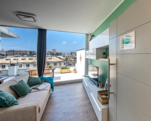 ein Wohnzimmer mit einem Sofa und einem großen Fenster in der Unterkunft Attico36 con parcheggio e vista mozzafiato in Genua