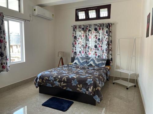a bedroom with a bed with a floral curtain at Hrishi’s home in Guwahati