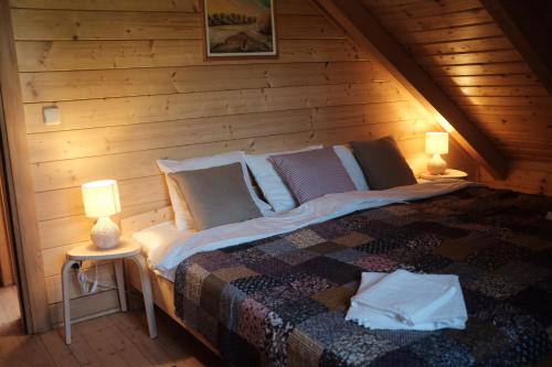uma cama numa cabina de madeira com dois candeeiros em Winery & Rural Holiday Home Hren Hiža - Sveti Martin na Muri em Gornji Koncovčak