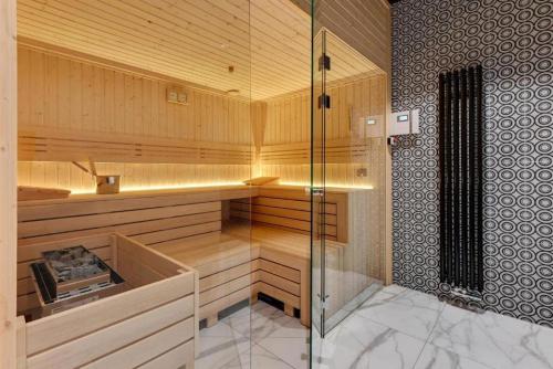 a sauna with a glass shower in a room at Downtown Apartments Nadmotławie Estate Gym, Sauna & Parking in Gdańsk
