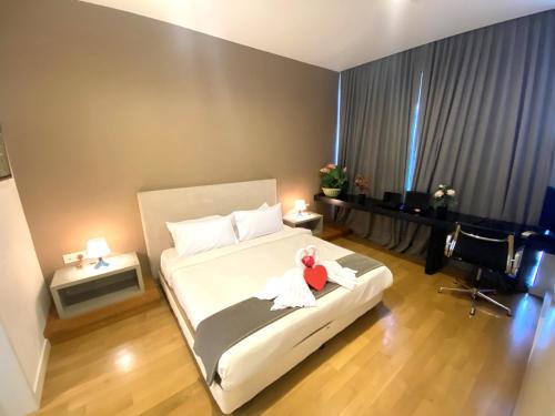 a bedroom with a bed with a teddy bear on it at KLCC Sky Villa Suites Platinum in Kuala Lumpur