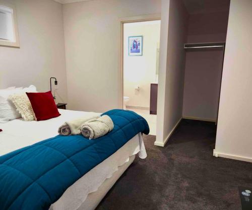 a bedroom with a bed with a blue blanket on it at Lucas One 2-bedroom apartment NBN Pets in Windermere