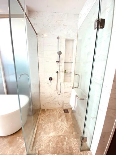 a bathroom with a shower and a tub and a sink at KLCC Sky Villa Suites Platinum in Kuala Lumpur