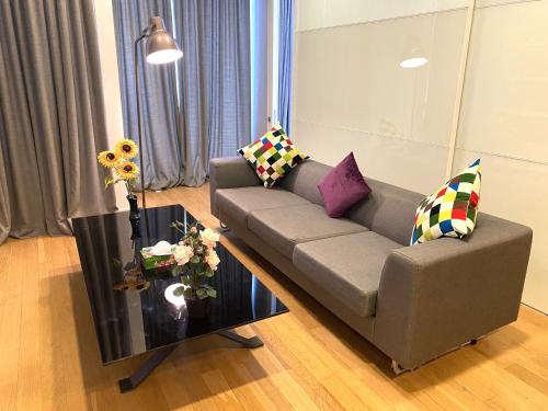 a living room with a couch and a table with pillows at KLCC Sky Villa Suites Platinum in Kuala Lumpur