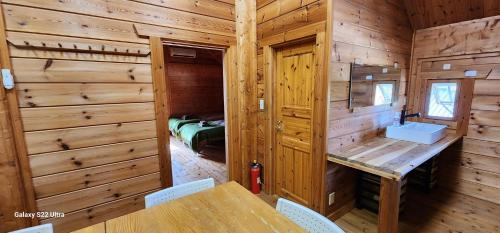 comedor con mesa y sillas en una cabaña de madera en まちなかlodge ほしとたきび Lodge in city Hoshi to Takibi, en Ōmuta
