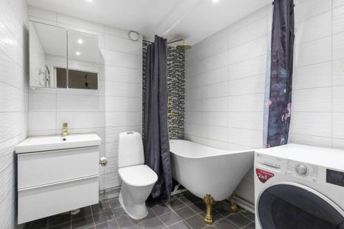 ein Badezimmer mit einer Badewanne, einem WC und einem Waschbecken in der Unterkunft Alby flexible checkin in Stockholm