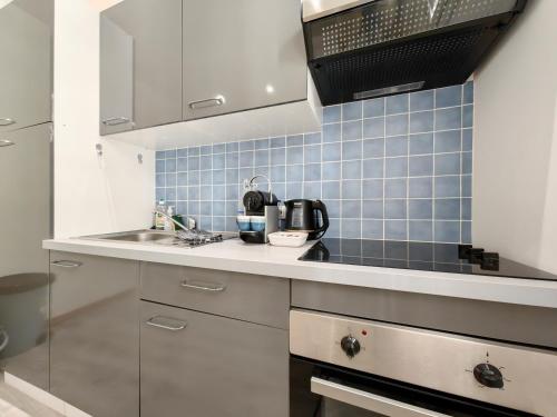 - une petite cuisine avec un évier et du carrelage bleu dans l'établissement Foch 3 by Booking Guys, à Villefranche-sur-Mer