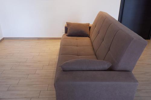 a brown couch sitting in a living room at appartamento fronte mare in Falconara Marittima