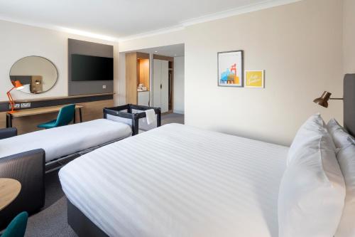 a hotel room with two beds and a tv at Holiday Inn High Wycombe M40, Jct.4 by IHG in High Wycombe