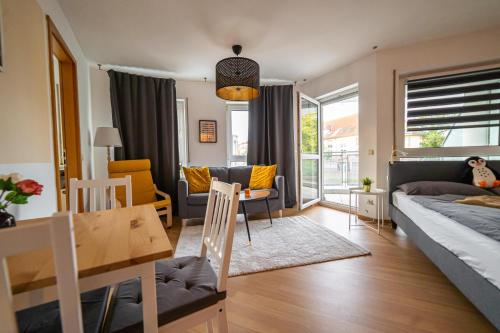uma sala de estar com uma cama e uma sala de jantar em FULL HOUSE Studios - KornhausPremium Apartment - Balkon, WiFi em Dessau