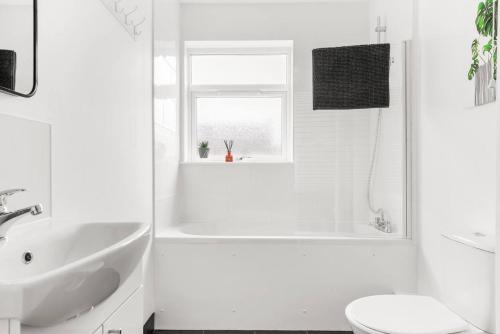 uma casa de banho branca com uma banheira e um lavatório em Stylish 4 Bed House in Yorkshire - Sleeps 9 em Hickleton