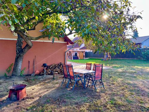 een tafel en stoelen onder een boom in een tuin bij Bikeaway Guesthouse in Kereki