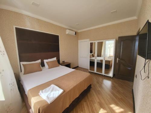 a bedroom with a large bed with a large headboard at Viva hotel Gabala with outdoor pool ,Sauna and Waterfall in Gabala