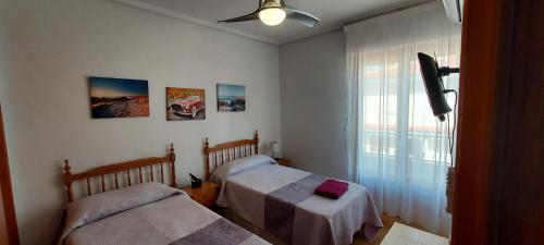 a bedroom with two beds and a window at Bungalow Fontilles 3 in Santa Pola