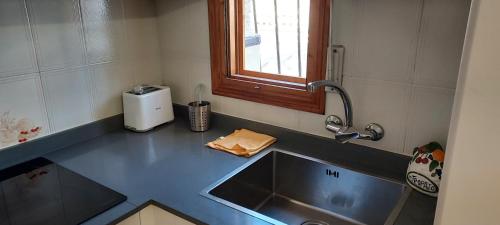 eine Küchentheke mit einem Waschbecken und einem Fenster in der Unterkunft Bungalow Fontilles 3 in Santa Pola