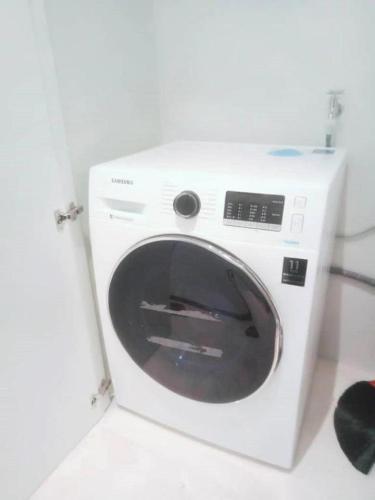 a white washing machine sitting in a room at KLCC Sky Villa Suites Platinum in Kuala Lumpur