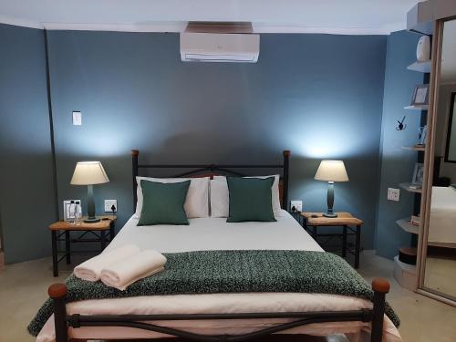 a bedroom with a bed with a blue wall at Leadwood Guesthouse in Tzaneen