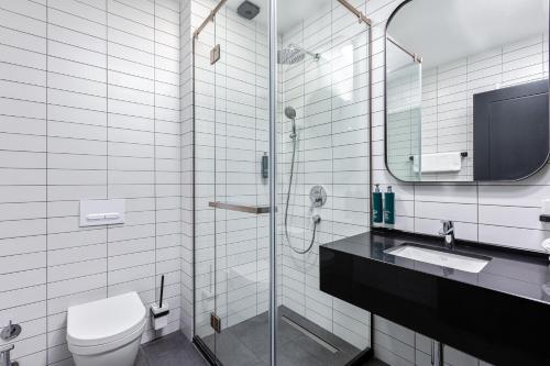 y baño con aseo, lavabo y ducha. en Gratus Aparthotel Tbilisi en Tiflis