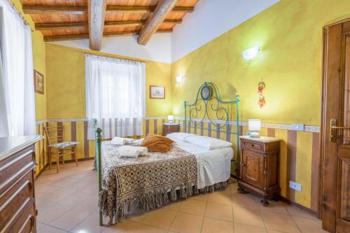 una camera con un letto in una stanza con pareti gialle di La Vecchia Fornace - Abetone, authentic farmhouse with private pool a Pian degli Ontani