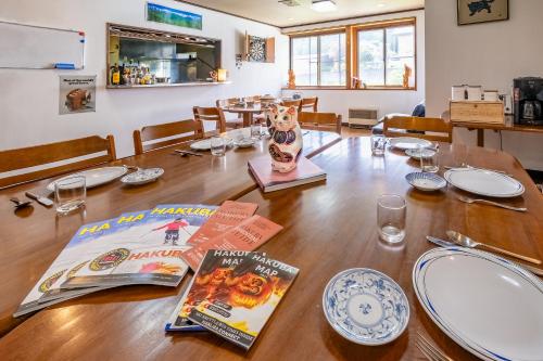 a dining room table with a book and plates on it at Iimori Vista in Hakuba
