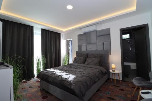 a bedroom with a large bed and a large window at Prestige Miskolctapolca in Miskolc