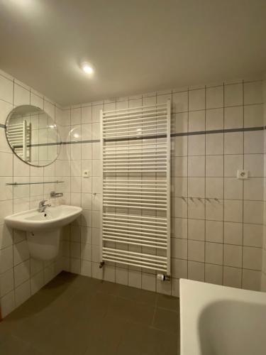 a white bathroom with a sink and a mirror at Apartmány Poustevník Resort in Pec pod Sněžkou