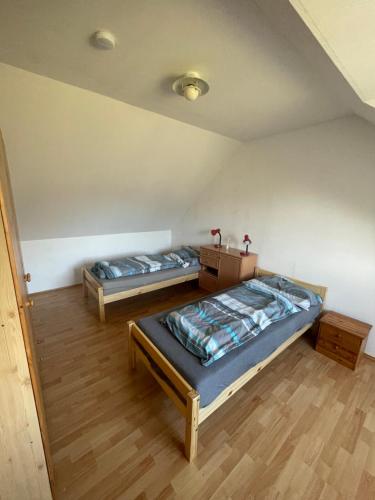 two twin beds in a room with wooden floors at Mariengestüt am Kreuzberg in Reichenau