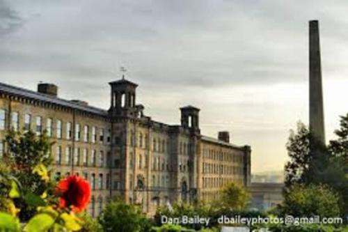 a large building with a red flower in front of it at Stylish 2-Bed Cottage in the heart of Yorkshire in Leeds
