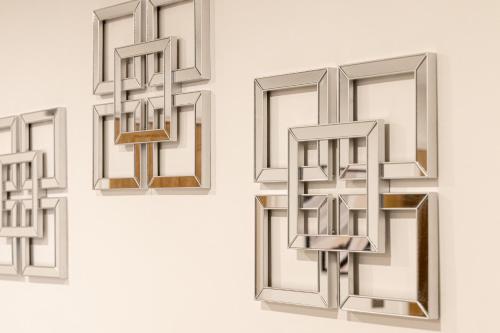 a group of mirrors hanging on a wall at Elms Cottage in Spalding