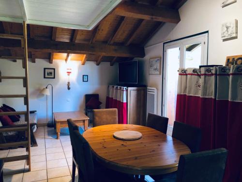 a dining room with a table and a refrigerator at Chalet en Haute Savoie Location ski 2 appartements pour 6 ou 8 personnes Saint Gervais Les Bains in Saint-Gervais-les-Bains